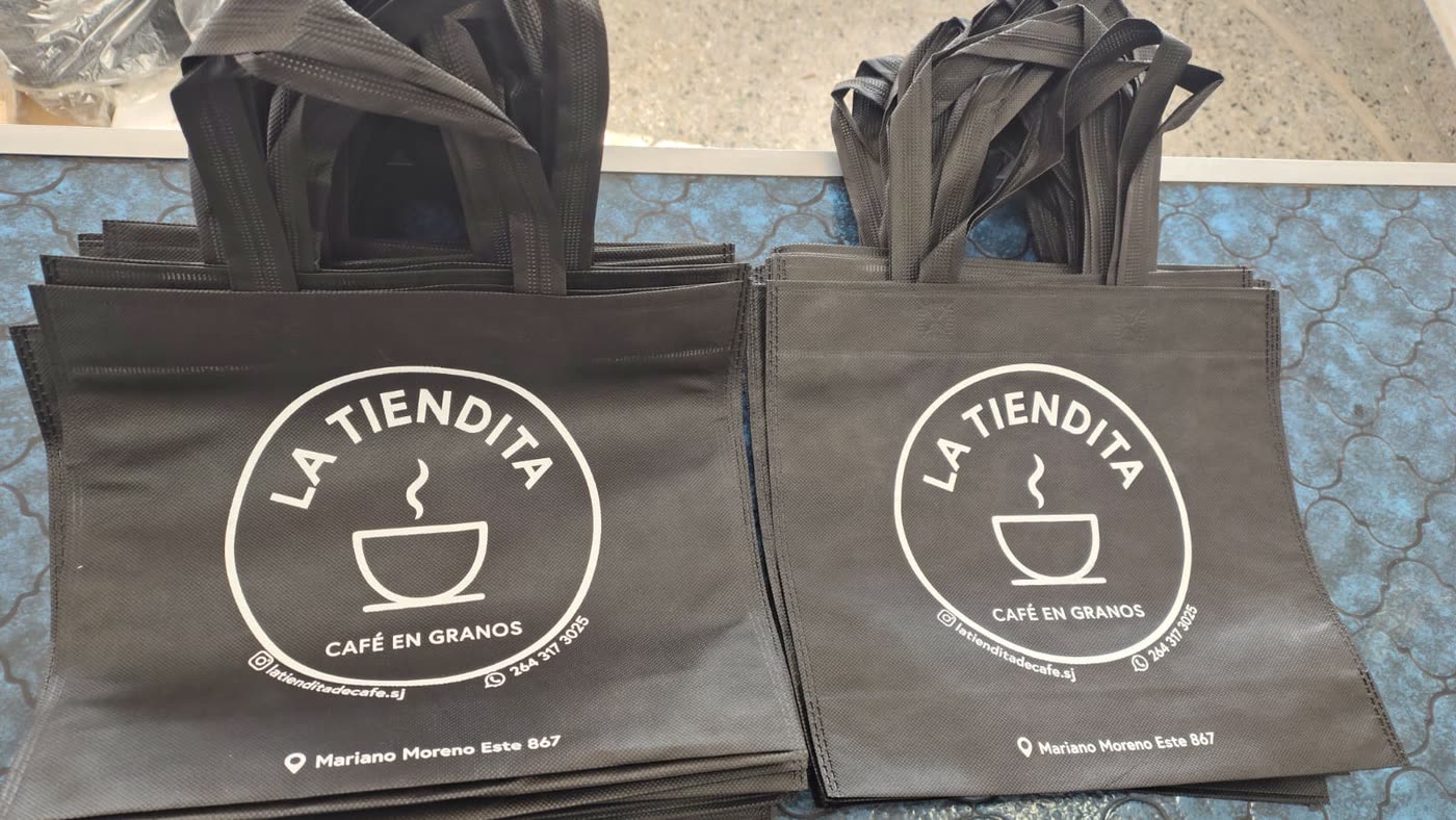 Bolsas de friselina negras con asas, estampadas en blanco para una cafeteria
